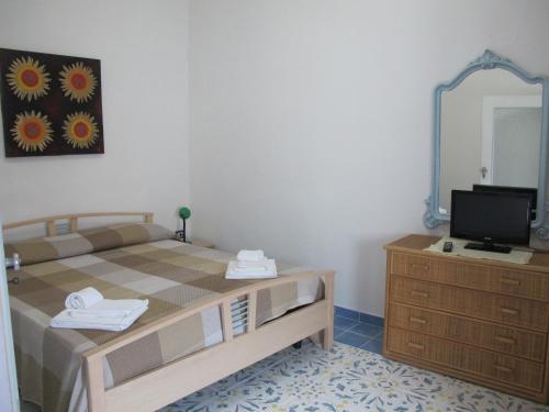 1 dormitorio con 1 cama y vestidor con espejo en Otranto Vacanza Facile - Via San Francesco Da Paola, en Otranto