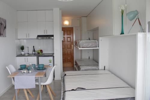エンプリアブラバにあるVentana a la Naturaleza (50m playa)のテーブル、ベッド、キッチンが備わる小さな客室です。