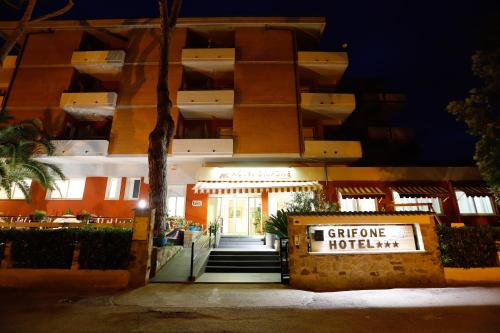 a building with a sign in front of it at Hotel Grifone in Principina a Mare