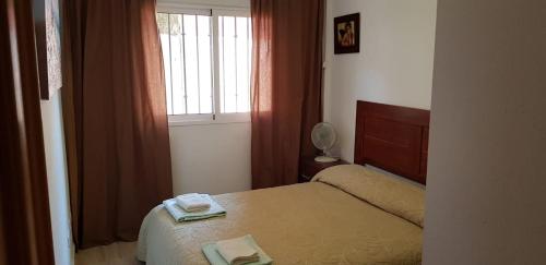 a small bedroom with a bed and a window at Beach Villa Grande in Santiago de la Ribera
