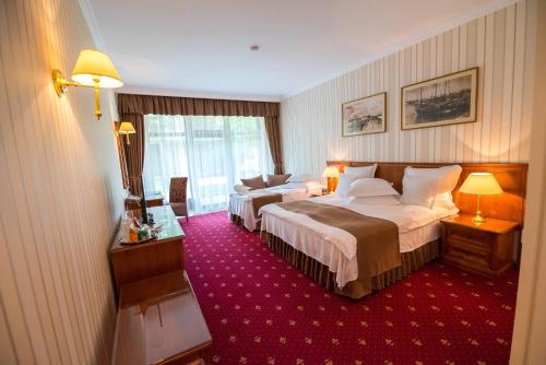 una camera d'albergo con due letti e un tappeto rosso di Club de Vacanta Mediterraneo a Neptun