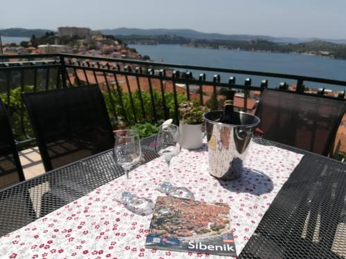 a table with two wine glasses and a book at Apartman Betty in Šibenik