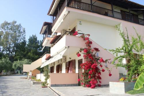 a building with flowers on the side of it at House Panorama Sea View in Neos Marmaras