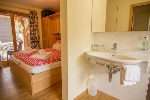 a small bathroom with a sink and a bed at Chalet Greta in Saas-Fee