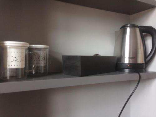 a kitchen shelf with a kettle and cups on it at Bhavantù in Boario Terme