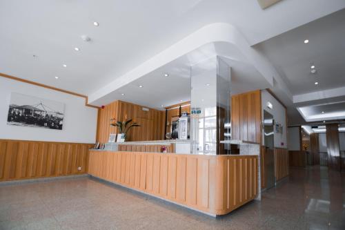 a kitchen with wooden cabinets and a counter in a room at Hotel Peregrinos de Fatima by Umbral in Fátima