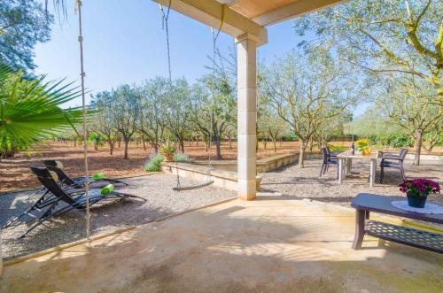 a patio with chairs and a table and a swing at Can Estelrich- Sant Blai in Campos