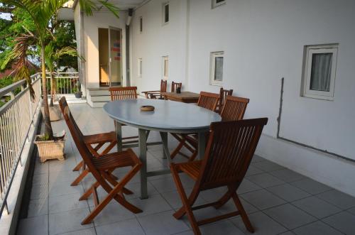 een patio met een tafel en stoelen op een balkon bij Huize Jon Hostel in Malang