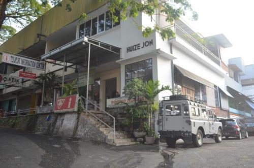 een witte truck geparkeerd voor een gebouw bij Huize Jon Hostel in Malang