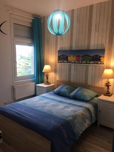 ヴィムルーにあるLes Oyats Proche Plageのベッドルーム1室(青い掛け布団付きのベッド1台付)
