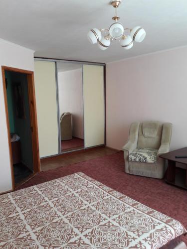 切爾卡瑟的住宿－Апартаменты в центре，一间卧室配有一张床、一把椅子和一张桌子