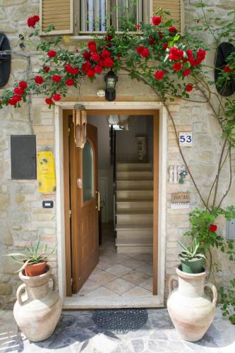 a building with a door with red flowers on it at B&B Villa Filetta in Marsia
