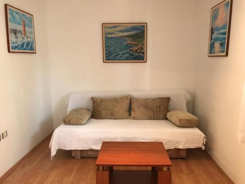 ein kleines Wohnzimmer mit einem Sofa und einem Tisch in der Unterkunft Apartment Pulić in Rab