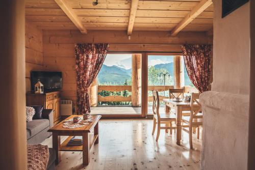 a living room with a table and chairs and a large window at Osada Kościelisko - Tatry na Wyciągnięcie Ręki in Kościelisko
