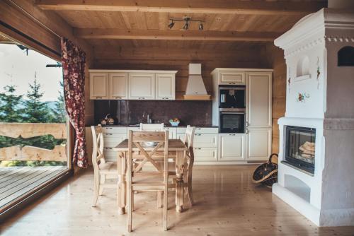 a kitchen with white cabinets and a table and chairs at Osada Kościelisko - Tatry na Wyciągnięcie Ręki in Kościelisko