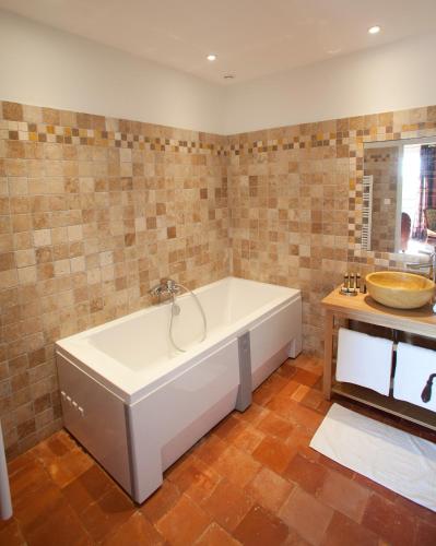 une grande salle de bain avec une baignoire et un lavabo dans l'établissement Gîtes la Vernède, à Nissan-lez-Enserune