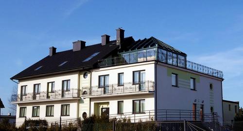 un gran edificio blanco con un balcón en la parte superior. en Koral, en Władysławowo