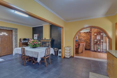 a dining room with a table with flowers on it at Casa da Tia Palmira in Castelo de Paiva