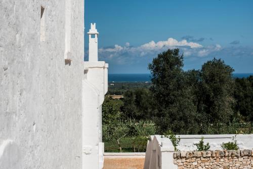 a white clock tower sitting on top of a stone wall at Masseria Le Carrube in Ostuni