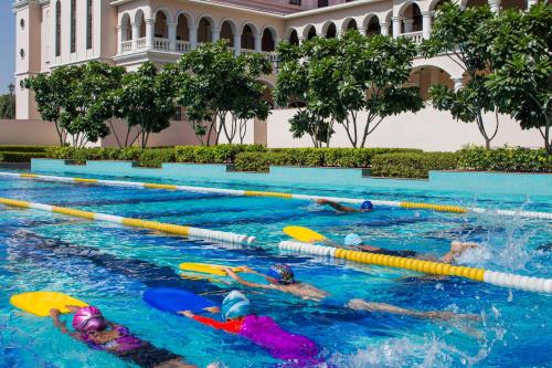 a group of people swimming in a swimming pool at DLF Club 5 in Gurgaon