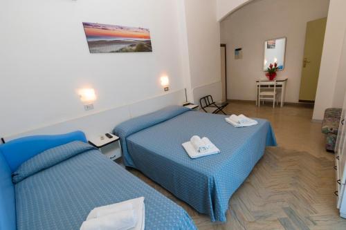 pokój hotelowy z 2 łóżkami i stołem w obiekcie Hotel Tre Assi w Rimini
