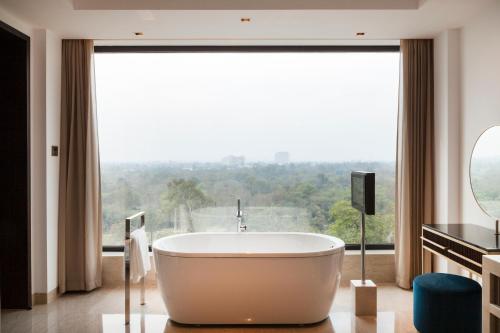 a bath tub in a bathroom with a large window at The Oberoi New Delhi in New Delhi