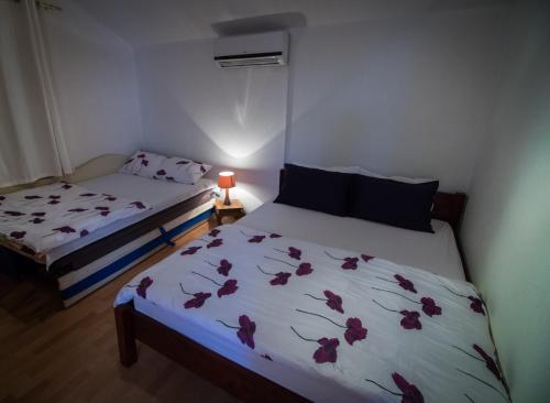 莫斯塔尔老城公寓式酒店的一间卧室配有两张带鲜花的床单