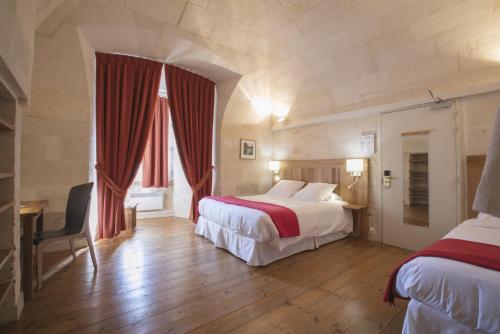 Tempat tidur dalam kamar di Les Chambres de l'Abbaye