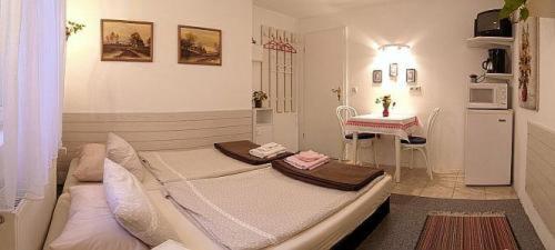 ein Schlafzimmer mit einem großen Bett und einem Tisch in der Unterkunft Lakeside Bed and Breakfast Berlin - Pension Am See in Falkensee