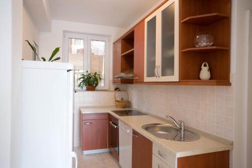 a kitchen with a sink and a refrigerator at Apartments Topo in Hvar