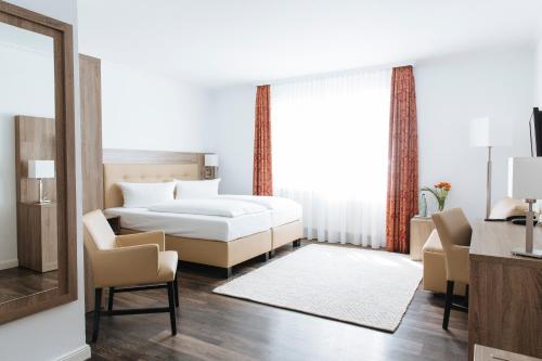 a bedroom with a bed and a table and chairs at Hotel Meerzeit Binz in Binz