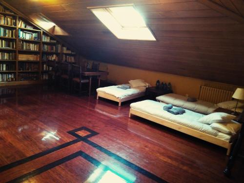 2 camas en una habitación con suelo de madera en Palacete Peñanora, en Oviedo