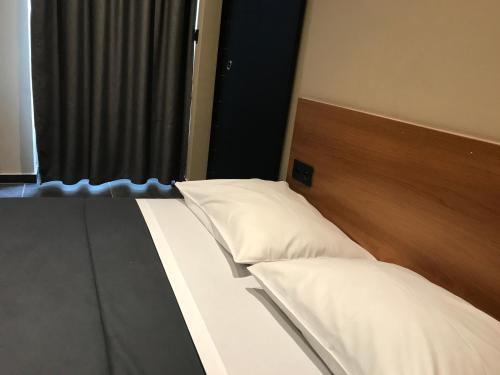 a bed with white pillows in a room with a window at Royal Hotel in Brussels