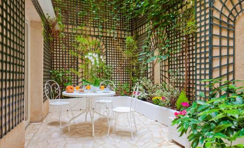 a patio with a table and chairs and plants at Hôtel Beaubourg in Paris
