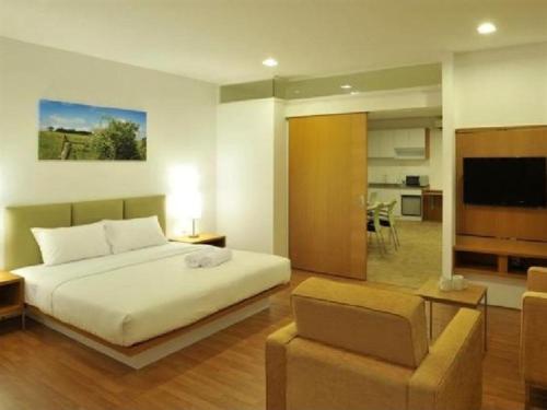 a bedroom with a bed and a living room at Hotel Primera Suite Cyberjaya in Cyberjaya