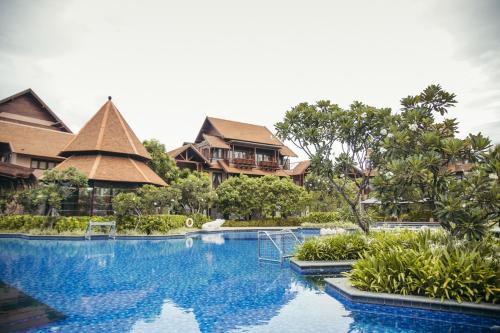a pool at a resort with houses in the background at Anantaya Resort and Spa Passikudah in Pasikuda