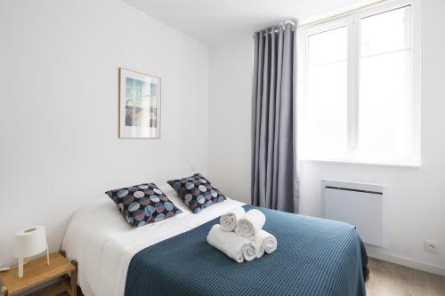 une chambre avec un lit avec des serviettes dessus dans l'établissement Mosaik by Cocoonr, à Nantes