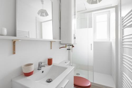 une salle de bain blanche avec un lavabo et une douche dans l'établissement Mosaik by Cocoonr, à Nantes