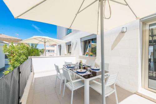 a table and chairs on a balcony with an umbrella at Formentera 1 in Can Picafort