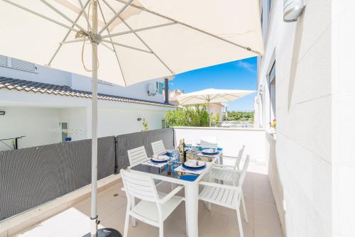 a table and chairs on a balcony with an umbrella at Formentera 1 in Can Picafort