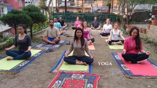 a group of people sitting in a yoga class at Everest Home Stay Apartment in Pātan