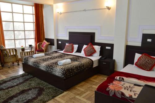 - une chambre avec 2 lits et des oreillers rouges dans l'établissement Hotel Auli D, à Jyotirmath