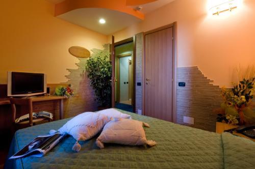 a bedroom with a bed with a pillow on it at Hotel Ristorante Tre Leoni in Somma Lombardo