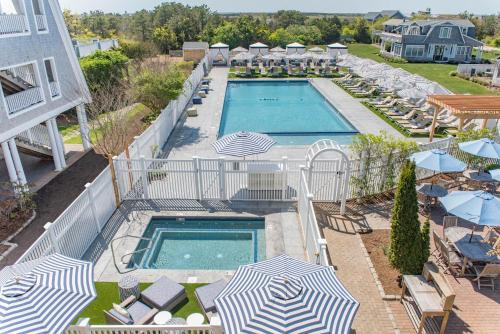 an overhead view of a swimming pool with umbrellas and chairs at Winnetu Oceanside Resort at South Beach in Edgartown