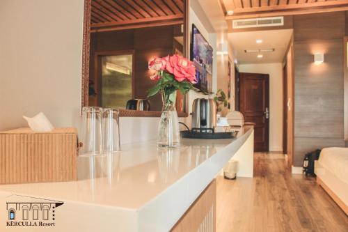 a kitchen with a vase of flowers on a counter at KERCULLA Resort in Gjirokastër