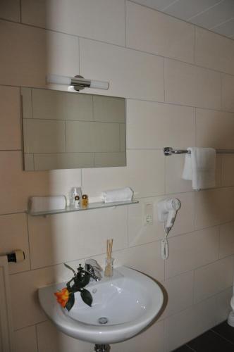 a bathroom with a white sink and a mirror at Gästezimmer Michelangelo in Rothenburg ob der Tauber