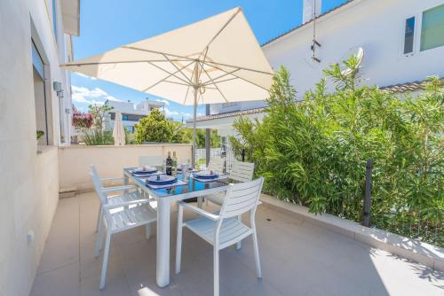 a patio with a table and chairs and an umbrella at Formentera 2 in Can Picafort