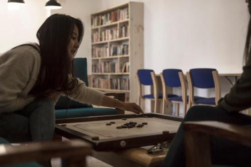 a young woman playing a game on a table at Ree Hostel in Leh
