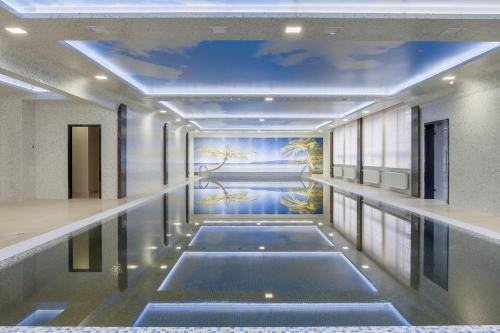 a swimming pool in a building with a painting on the ceiling at Grand Hotel Bezhitsa in Bryansk