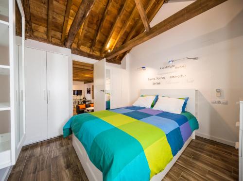ein farbenfrohes Bett in einem Schlafzimmer mit Holzdecken in der Unterkunft Livings en Elvira Centro in Granada
